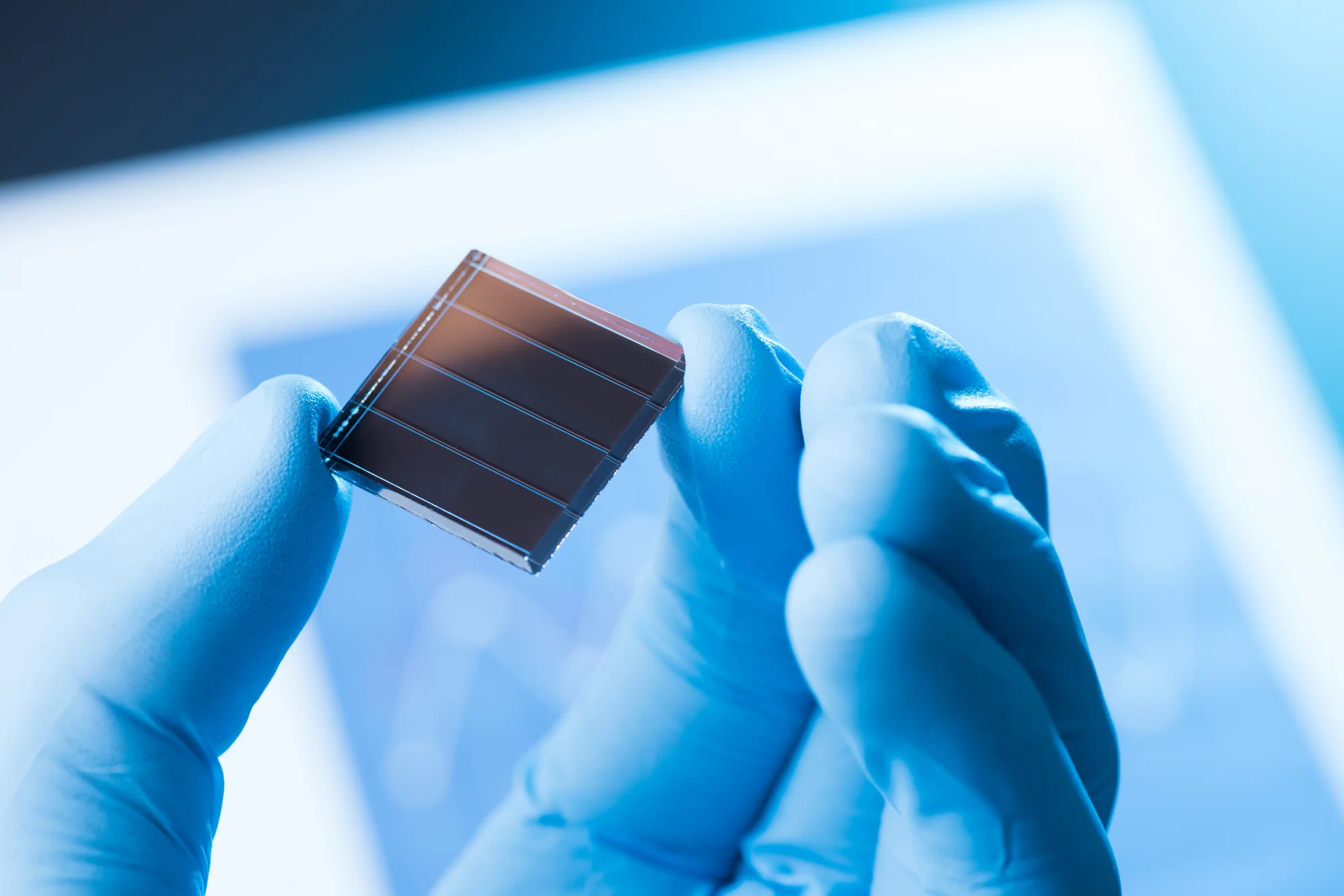 Researcher holding a thin-film CdTe solar cell in the laboratory